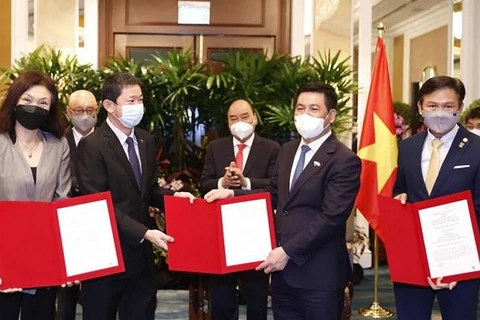 Президент Нгуен Суан Фук стал свидетелем заключения соглашений о сотрудничестве между вьетнамскими предприятиями и Sembcorp Group. (Фото: ВИА)