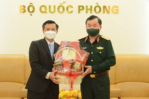 Заместитель министра национальной обороны генерал-полковник Хоанг Суан Чиен (справа) вручает подарки заместителю посла Лаоса во Вьетнаме Чантафону Хамманичану по случаю лаосского праздника Бунпимай. (Фото: ВИА)