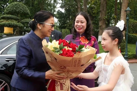 Вице-президент Лаоса Пани Ятотоу (слева) получает букет от вьетнамской девушки. (Фото: ВИА)