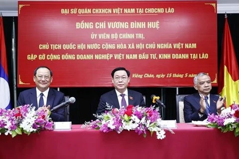 Председатель НС Выонг Динь Хюэ (слева) встречается с представителями вьетнамского бизнеса в Лаосе 15 мая. (Фото: ВИА)