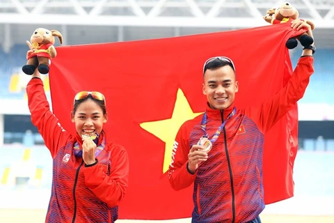 Нгуен Тхи Тхань Фук, золотая медалистка в женской ходьбе на 20 км, и ее брат Нгуен Тхань Нгунг, бронзовый медалист в мужской ходьбе на 20 км, позируют фотографу. (Фото: ВИА)
