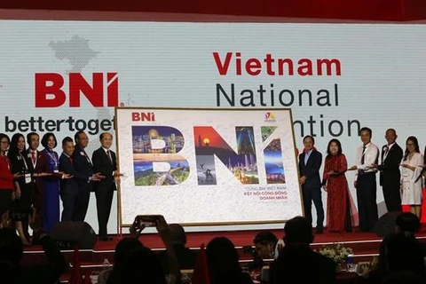 Хо Куанг Минь, президент BNI Vietnam (7-й слева), передает фотографию с подписями предпринимателей представителю Управленияа туризма города Дананг. (Фото: ВИА)