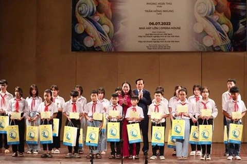 Вице-президент Нгуен Тхи Ань Суан и министр труда и социальных дел Дао Нгок Зунг вручают стипендии детям из неблагополучных семей на мероприятии (Фото: ВИА)
