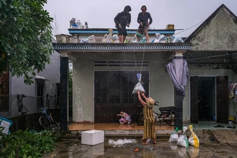 Семья укрепляет крышу дома перед приходом тайфуна Нору в южно-центральной провинции Куангнам 27 сентября. (Фото: ЮНИСЕФ)