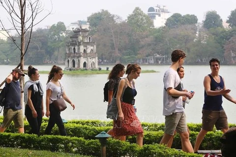 Иностранные туристы возле озера Хоанкием в центре Ханоя. (Фото: ВИА)