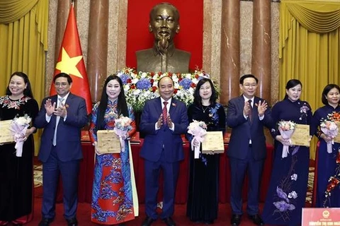 Президент государства Нгуен Суан Фук, премьер-министр Фам Минь Тьинь и председатель НС Выонг Динь Хюэ вручили цветы женщинам-делегатам. (Фото: ВИА)