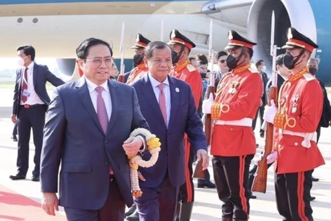 Высокопоставленные официальные лица Камбоджи приветствуют премьер-министра Фам Минь Тьиня в международном аэропорту Пномпеня. (Фото: ВИА)