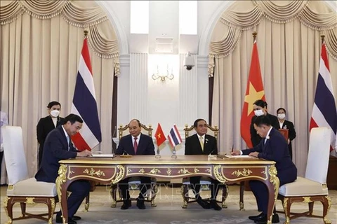 Президент Нгуен Суан Фук (сидит слева) и премьер-министр Прают Чан-Оча (сидит справа) наблюдают за подписанием Меморандум о взаимопонимании, устанавливающий отношения сотрудничества и дружбы между городом Дананг и провинцией Кхонкэн, Таиланд. (Фото: ВИА) 