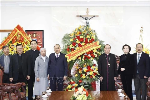 Президент Нгуен Суан Фук вручает цветы для поздравления Ханойской архиепископии. (Фото: ВИА)