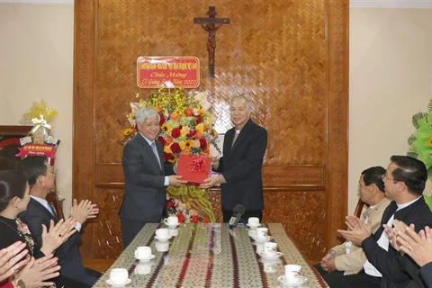 Председатель Центрального комитета Отечественного фронта Вьетнама (ОФВ) До Ван Чиен вручает рождественские подарки епископу Нгуен Хунг Ви, епископу епархии Контум. (Фото: ВИА)