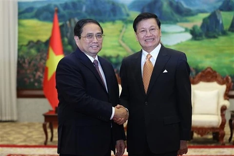 Премьер-министр Фам Минь Тьинь (слева) и генеральный секретарь ЦК НРПЛ, президент Лаоса Тонглун Сисулит на встрече во Вьентьяне 11 января. (Фото: ВИА)