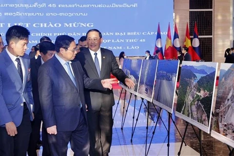 Премьер-министр Фам Минь Тьинь и премьер-министр Лаоса Сонексай Сипхандоне посещают фотогалерею. (Фото: ВИА)