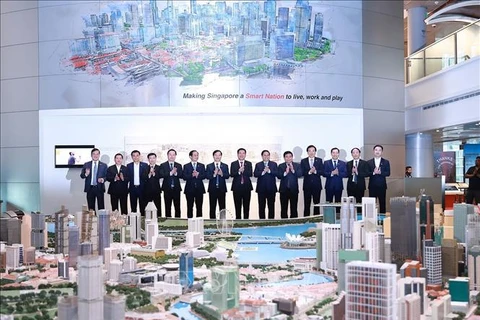 Премьер-министр Фам Минь Тьинь и делегаты посещают Сингапурскую выставку умного национального планирования в URA Center. (Фото: Зыонг Жанг/ВИА)
