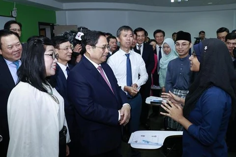 Премьер-министр Фам Минь Тьинь беседует со студентами, изучающими вьетнамский язык в Национальном университете Брунея. (Фото: газета Нян Зян)