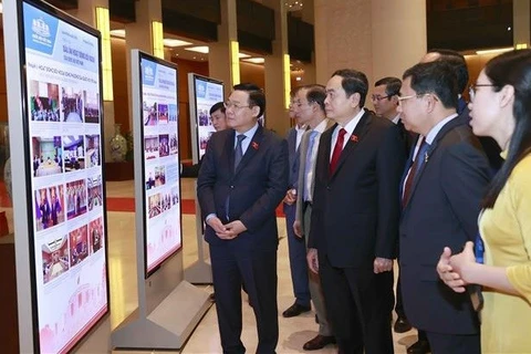 Делегаты посещают фотовыставку, посвященную внешней политике Национального собрания. (Фото: ВИА)