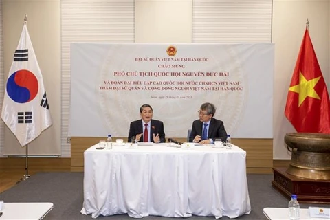 Заместитель председателя НС Нгуен Дык Кхай (слева) выступает на встрече с сотрудниками посольства Вьетнама и представителями вьетнамской общины в РК 19 марта. (Фото: ВИА)