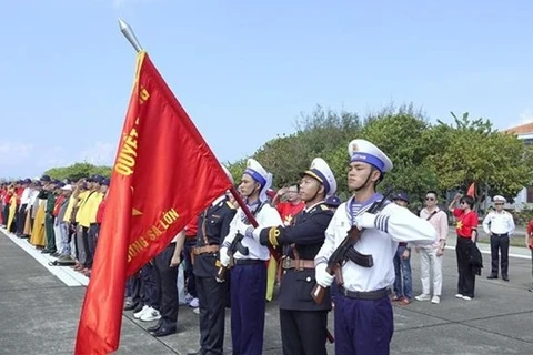 Делегаты принимают участие в церемонии поднятия флага в уезде острова Чыонгша (Фото: ВИA)