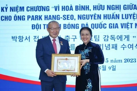 Посол Нгуен Фыонг Нга (справа) вручает знак отличия тренеру Пак Ханг Сое. (Фото: ВИA)