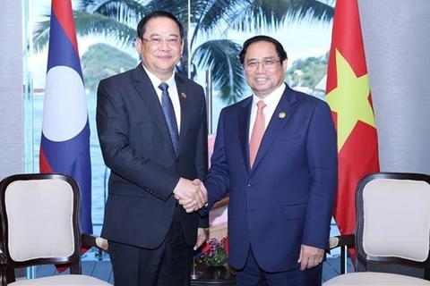 Премьер-министр Фам Минь Тьинь (справа) встречается со своим лаосским коллегой Сонексаем Сифандоне в Лабуан Баджо, Индонезия, 10 мая. (Фото: ВИА)