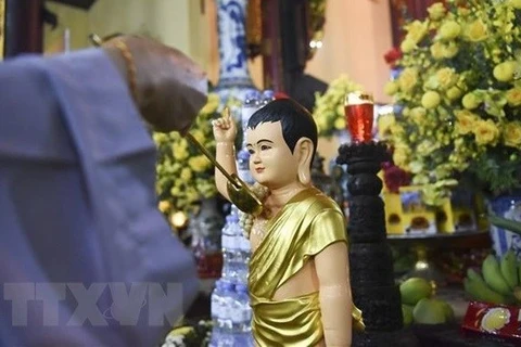 Буддист практикует ритуал Омовения Будды. (Фото: ВИA) 