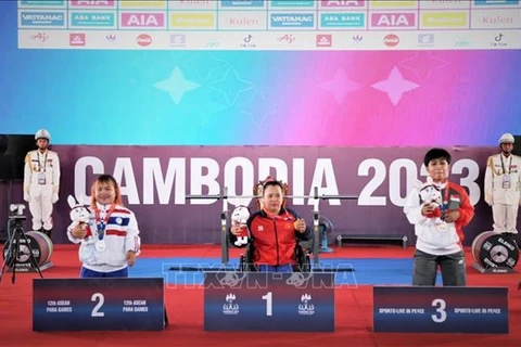 Тяжелоатлет Данг Тхи Линь Фыонг (в центре) на 12-х Паралимпийских играх АСЕАН. (Фото: ВИА) Ле Ван Конг получает золот