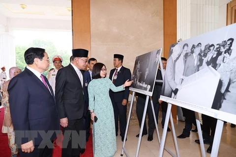 Премьер-министр Фам Минь Тьинь и премьер-министр Малайзии Анвар Ибрагим посетили фотовыставку ВИА. (Фото: Зыонг Жанг/ВИА)