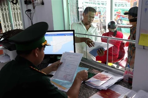 Сотрудники Пограничной службы Шонгдок (Камау) тщательно проверяют документы судовладельца перед выходом в море на рыбную ловлю. (Фото: ВИА) 