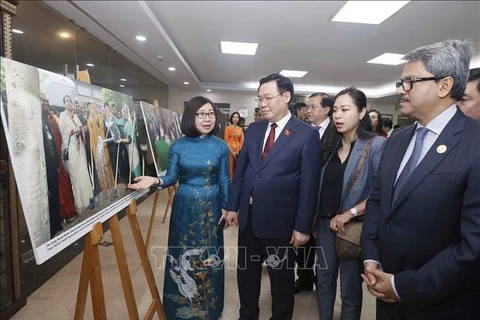Председатель Национального собрания Выонг Динь Хюэ и делегаты рассматривают выставку. (Фото: Доан Тан/ВИА)