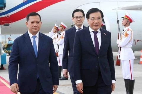 Премьер-министра Камбоджи Самдех Моха Бовор Тхипадей Хун Мане (слева) встречает министр - заведующий канцелярией правительства Чан Ван Шон (спереди, справа) в международном аэропорту Нойбай утром 11 декабря. (Фото: ВИA) 