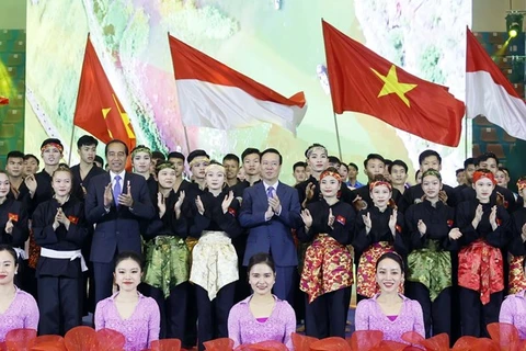Президент Во Ван Тхыонг (второй ряд, пятый справа) и его индонезийский коллега Джоко Видодо (третий слева) на совместном фото со спортсменами и артистами во время программы в Ханое 12 января (Фото: ВИA)