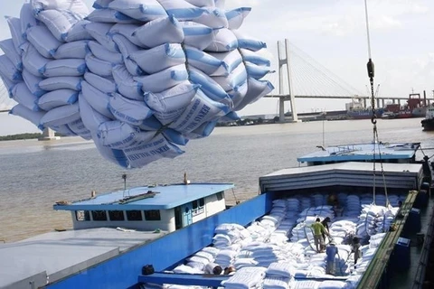 Мешки с рисом грузят на судно для транспортировки. (Фото: ВИA)