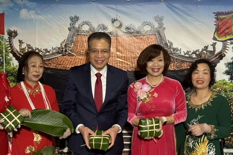 Посол Данг Минь Кхой, его супруга и сотрудники посольства делают традиционный новогодний пирог баньчынг. (Фото: ВИА)