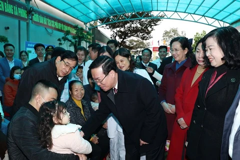 Президент Во Ван Тхыонг посещает медицинский пункт общины Тханьфонг в уезде Тханьлием провинции Ханам 25 февраля. (Фото: ВИA)