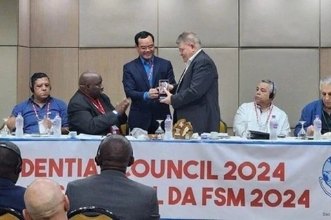 Председатель Всеобщей конфедерации труда Вьетнама (VGCL) Нгуен Динь Кханг вручает подарок лидерам Всемирной федерации профсоюзов (WFTU). (Фото: ВИA) 