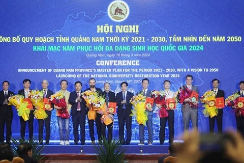 Руководители провинции Куангнам представляют предприятиям решения об утверждении инвестиционной политики на конференции. (Фото: baoquangnam.vn)