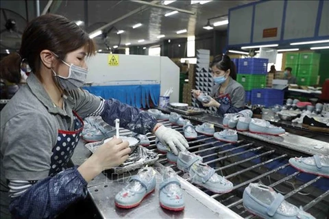 Рабочие производят обувь на экспорт на фабрике Ha Tay Chemical - Weave Co. Ltd. (Фото: ВИA)