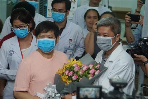 Заместитель министра здравоохранения Вьетнама Нгуен Чыонг Сон поздравляет китайского пациента Ли Дину с его выздоровлением (Фото: ВИА)