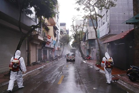 Медицинские работники проводят дезинфекцию улицы Чаулонг в районе Чукбах в Ханое. (Фото: ВИА)