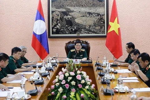 Министр обороны Вьетнама генерал Нго Суан Лить (в центре) проводит телефонные переговоры со своим лаосским коллегой генералом Чансамоне Чаньялатом (Фото: ВИА)