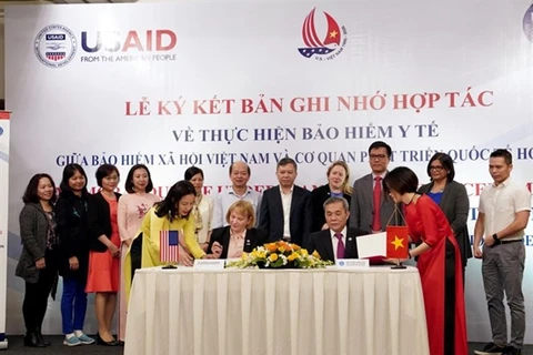 Директор миссии USAID во Вьетнаме Энн Мари Ястишок (вторая слева) и заместитель генерального директора службы социального страхования Вьетнама Фам Лыонг Шон (второй справа) подписали меморандум о взаимопонимании по поддержке медицинского страхования (фото