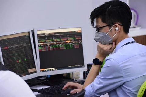 Инвестор следит за движением акций на экране компьютера (Фото: tinnhanhchungkhoan.vn)