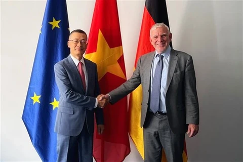 Посол Вьетнама в Германии Ву Куанг Минь (слева) обменивается рукопожатием с Йохеном Фласбартом, государственным секретарем Федерального министерства экономического сотрудничества и развития Германии, 23 июня. (Фото: ВИА)