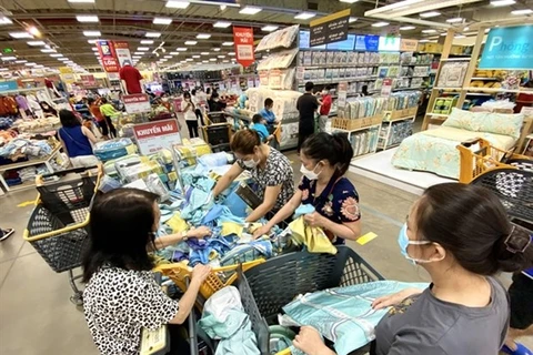 Поскольку снижение налогов привело к снижению цен на многие продукты, покупатели устремились в супермаркеты в поисках выгодных предложений. (Фото: tuoitre.vn)