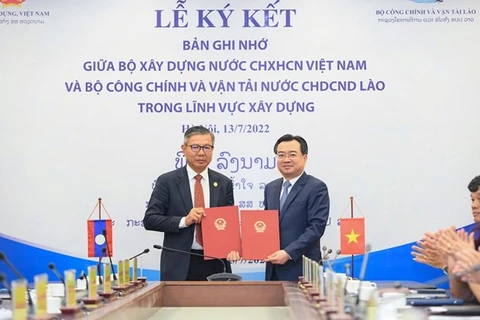 Министр строительства Нгуен Тхань Нги (справа) и министр общественных работ и транспорта Лаоса Виенгсават Сипандоне (Фото: ВИА) 