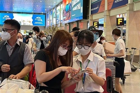 Сотрудник авиакомпании помогает пассажиру пройти регистрацию в международном аэропорту Таншоннят в Хошимине. (Фото: ВИА) 