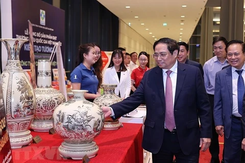  Премьер-министр Фам Минь Тьинь посещает выставку, в которой представляют продукты, получившие в 2022 году национальный бренд Вьетнама. (Фото: Vietnam+) 