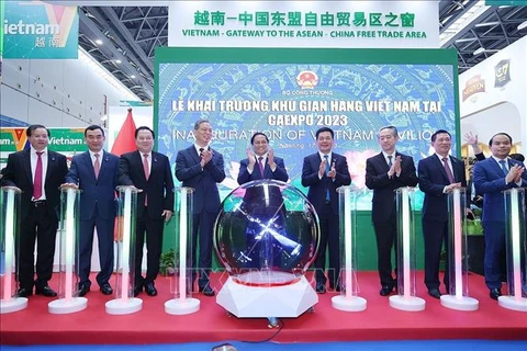 Премьер-министр Фам Минь Тьинь и делегаты открыли торговый павильон Вьетнама. (Фото: ВИА)
