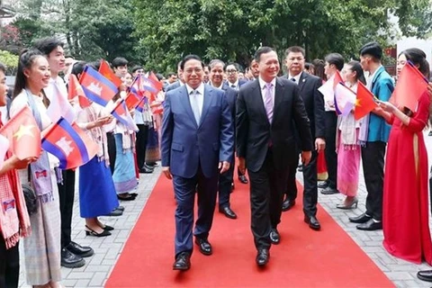 Премьер-министр Фам Минь Тьинь и премьер-министр Камбоджи Самдек Моха Борвор Тхипадей Хун Мане посещают Университет внешней торговли в Ханое 12 декабря (Фото: ВИA)
