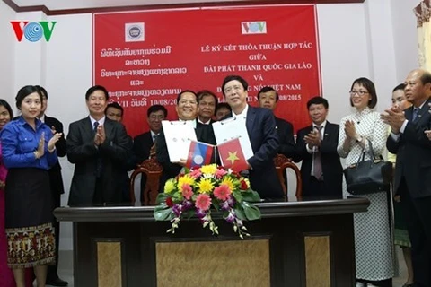 越南国家广播电台台长阮登进与老挝国家广播电台台长西帕·农拉在签署仪式