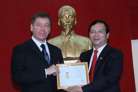 越南友好组织联合会副主席裴克山向乌克兰驻越南大使奥雷克谢授予“致力于各民族和平友谊”纪念章（图片来源：越共电子报）